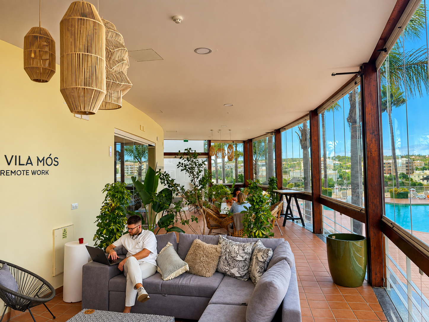 Members relaxing and working in the poolside lounge at Vila Mós