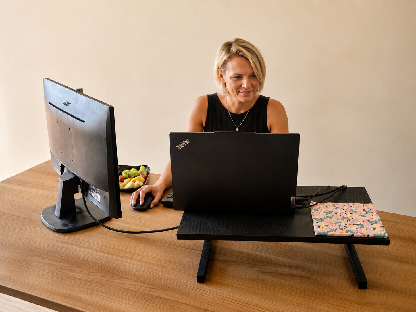 Member working at a dedicated desk with monitor and laptop riser at Lifestyle @ Vila Mós