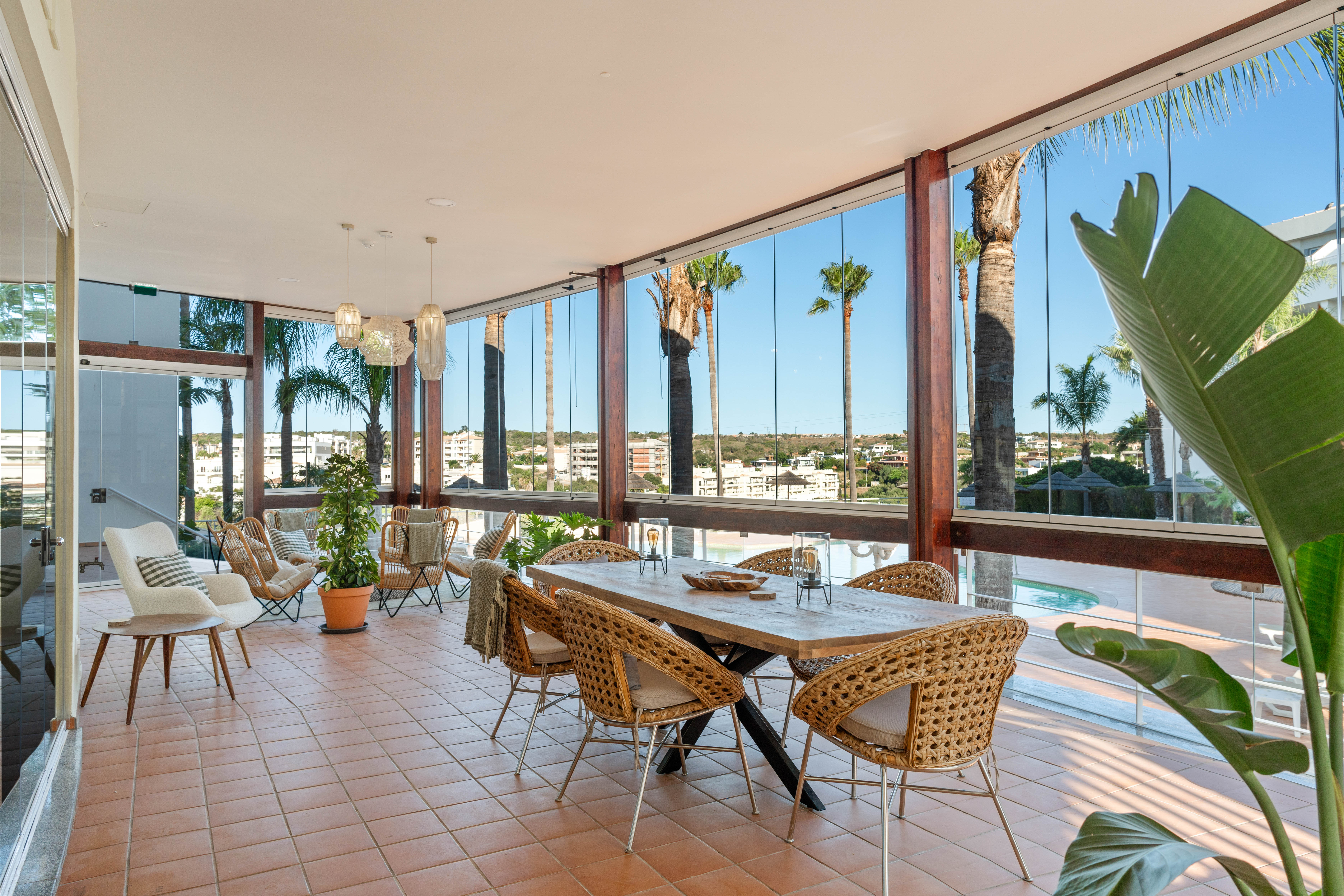 Glazed veranda with pool view and lounge seating